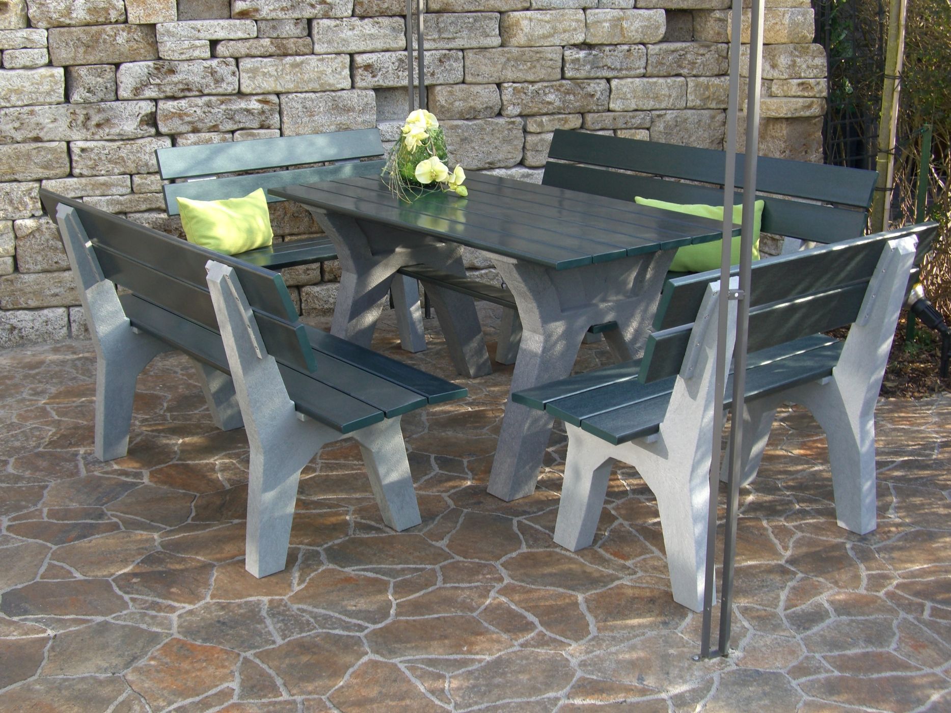 Ein Tisch mit Stühlen in einem Garten, bereit für eine gesellige Zusammenkunft oder ein entspanntes Essen.
